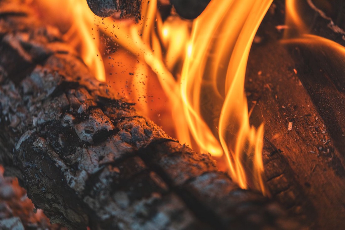 Flammes vives sur des bûches en combustion, gros plan