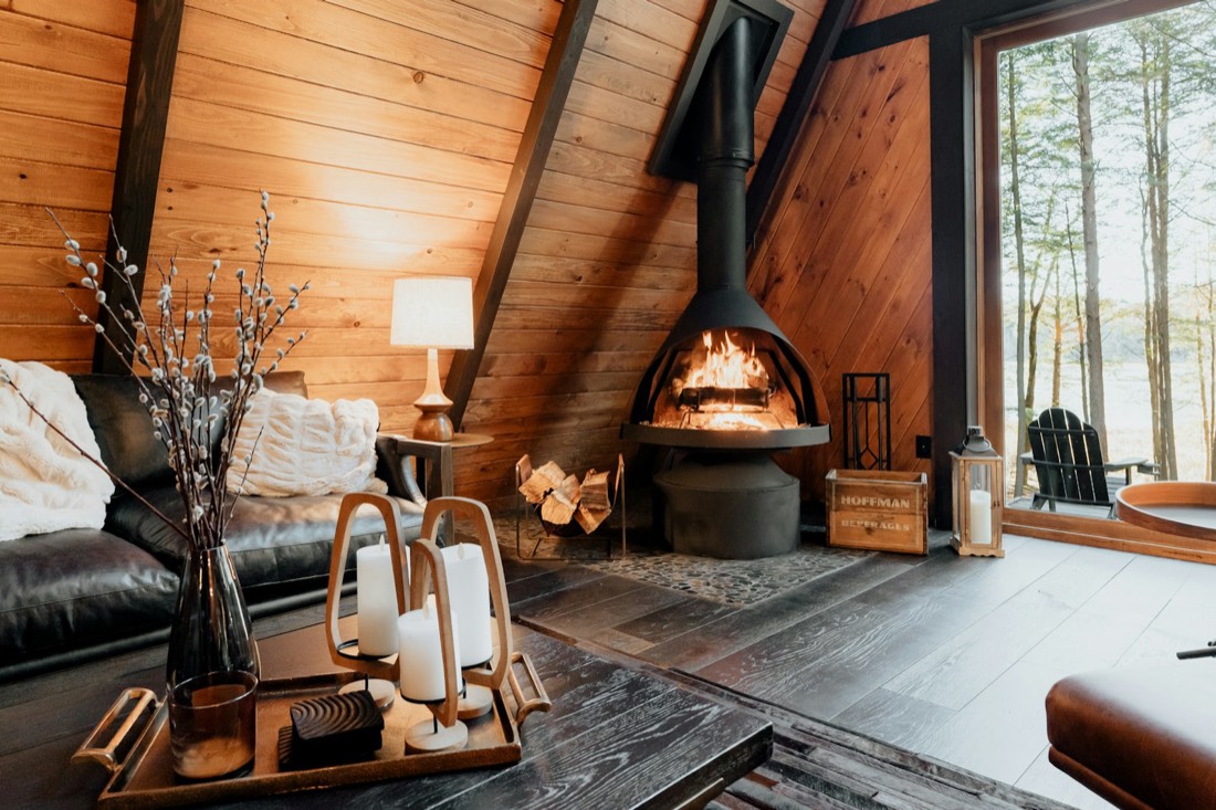 Salon chaleureux tout en bois avec poêle central allumé